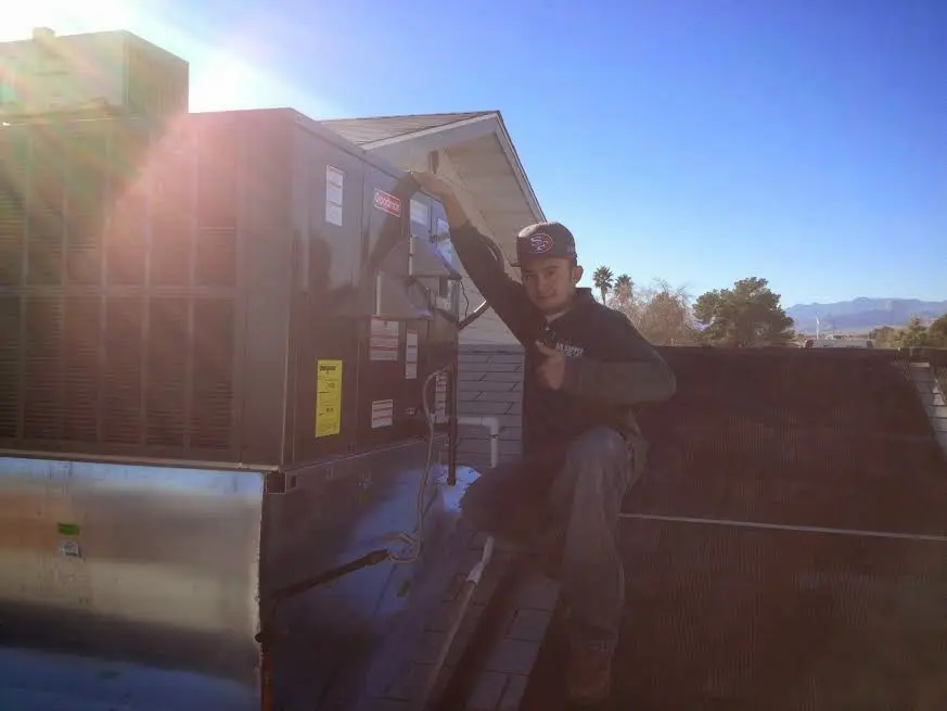 HVAC technician performing Air Duct Repair on a rooftop unit in Oakland
